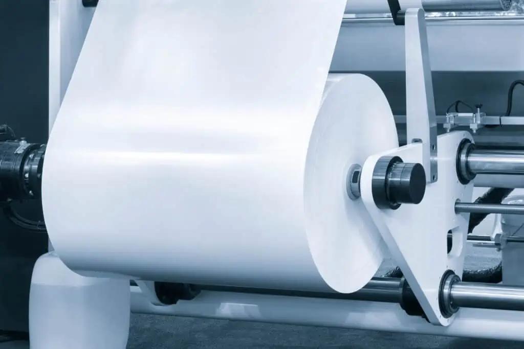 Roll-to-roll manufacturing process with web material on industrial machinery